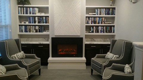 a living room with two chairs and a fireplace